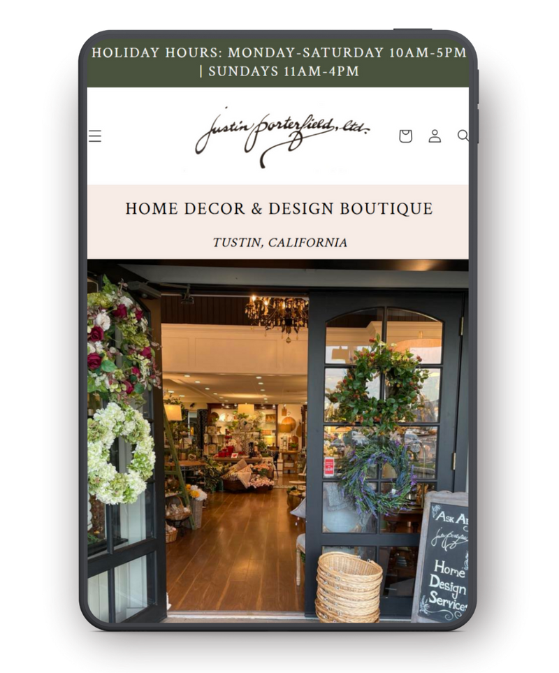 Phone screen displaying a home decor and design boutique website with store front image.